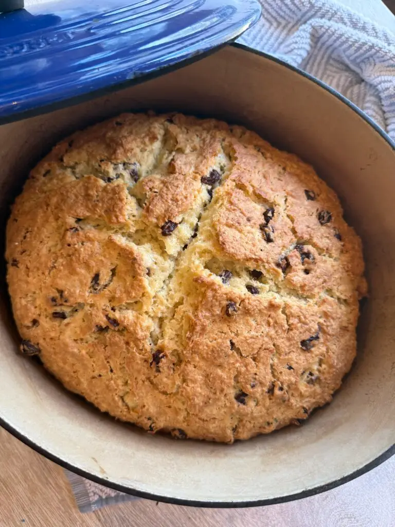 close up of Irish Soda Bread, baked in an enameled pot, sitting on a table