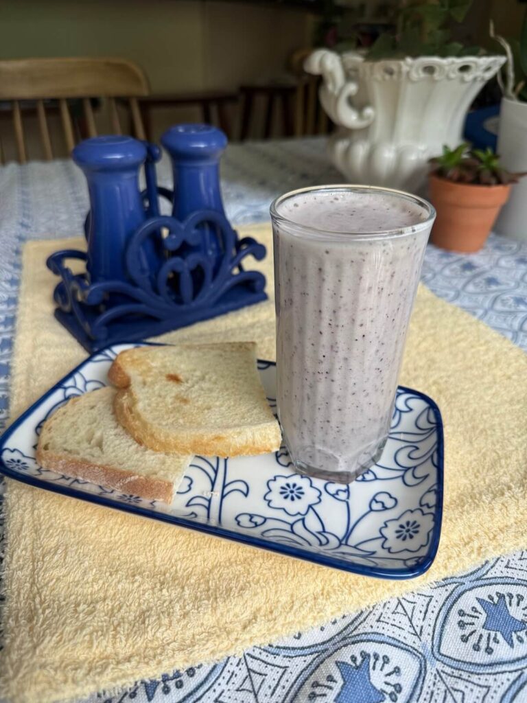 Cucumber Blueberry Basil Refresher Smoothie on a blue and white plate alongside toast