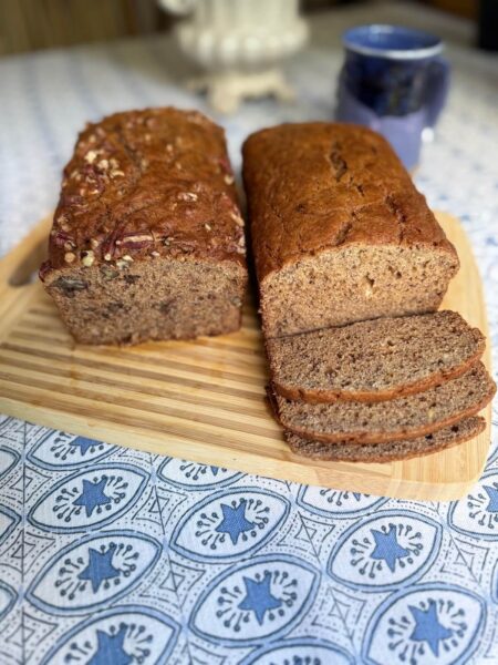 Mom's Whole Wheat Banana Bread with two variations: a pecan-topped loaf and a plain loaf sliced to reveal its moist crumb.